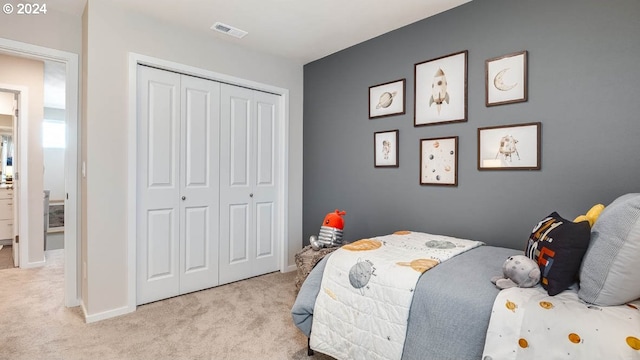 bedroom featuring baseboards, visible vents, a closet, and light carpet