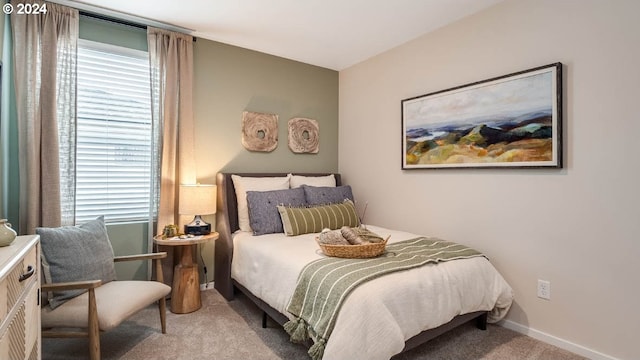 bedroom with baseboards, multiple windows, and light colored carpet