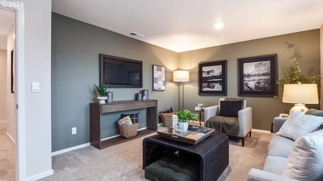 living room featuring baseboards, visible vents, and light colored carpet