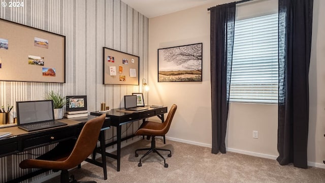 office with wallpapered walls, baseboards, and light carpet