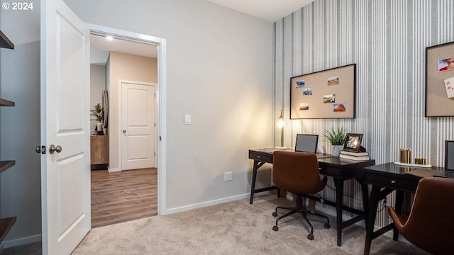 home office with baseboards, wallpapered walls, and light carpet