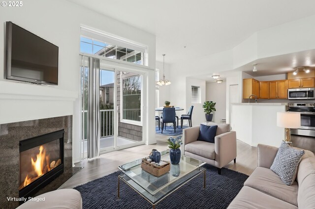 living room featuring wood finished floors and a glass covered fireplace