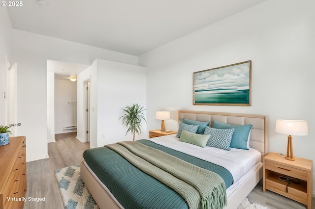 bedroom featuring a baseboard radiator and wood finished floors