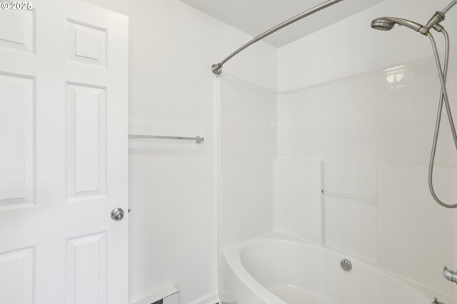 full bath with bathtub / shower combination and a baseboard heating unit