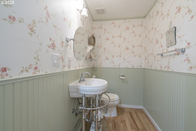 half bathroom featuring wood finished floors and toilet