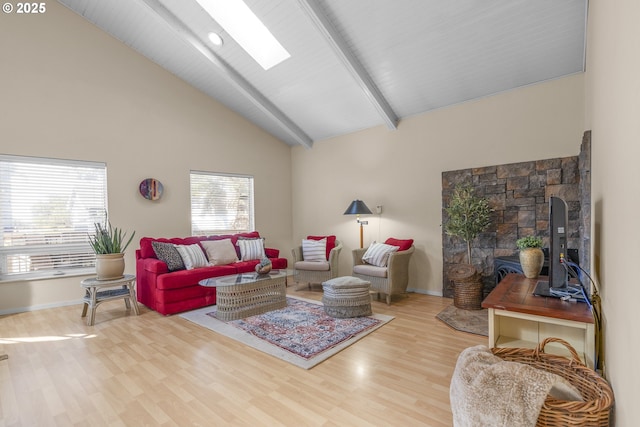 living room featuring wood finished floors, beam ceiling, baseboards, high vaulted ceiling, and a skylight