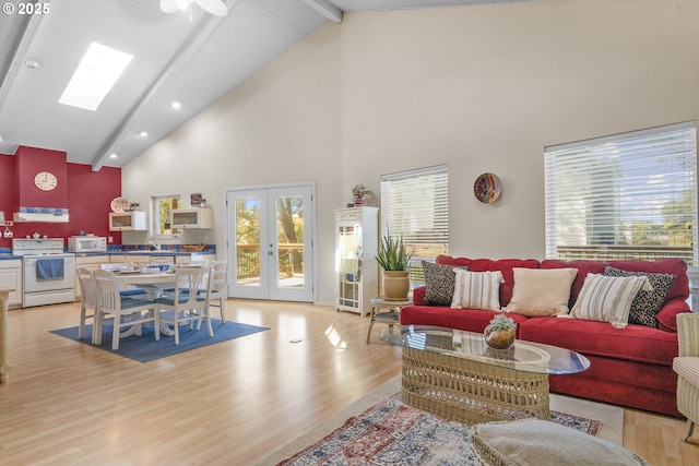 living room featuring high vaulted ceiling, french doors, beamed ceiling, light wood-style floors, and a skylight