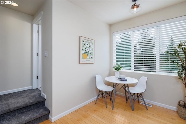 dining space with baseboards, wood-type flooring, and visible vents