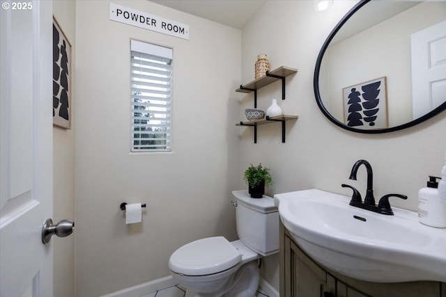 half bathroom with toilet, vanity, and baseboards