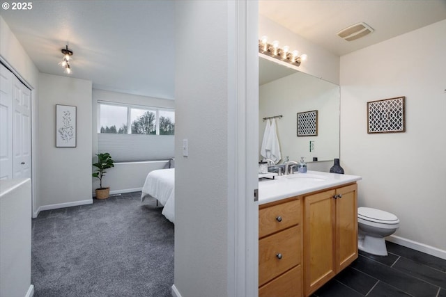 bathroom with visible vents, toilet, vanity, and baseboards