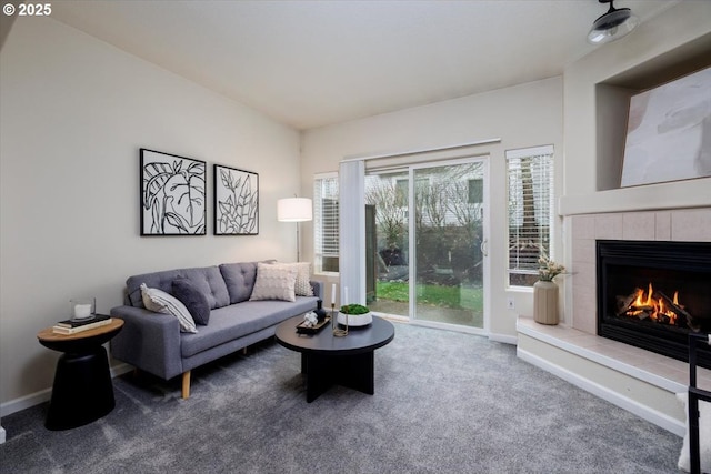 living room featuring baseboards, carpet, and a tiled fireplace