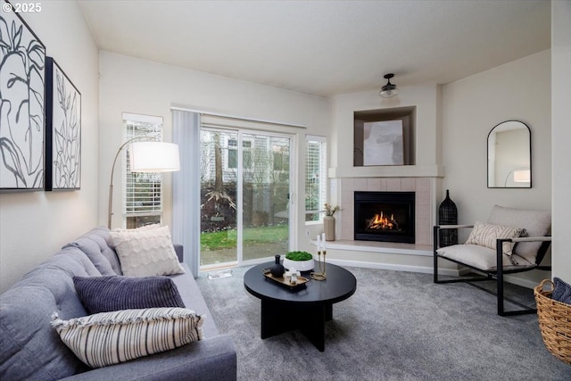 carpeted living room featuring a tile fireplace