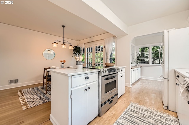3954 NE 38th Ave, Portland, OR 97212 - kitchen with stainless steel electric range oven, light wood-type flooring, freestanding refrigerator, and light countertops