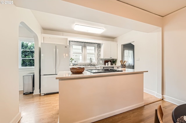 3954 NE 38th Ave, Portland, OR 97212 - kitchen with freestanding refrigerator, black electric cooktop, white cabinetry, light countertops, and light wood-style flooring