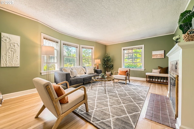 3954 NE 38th Ave, Portland, OR 97212 - living room with plenty of natural light, ornamental molding, wood finished floors, a textured ceiling, and a glass covered fireplace