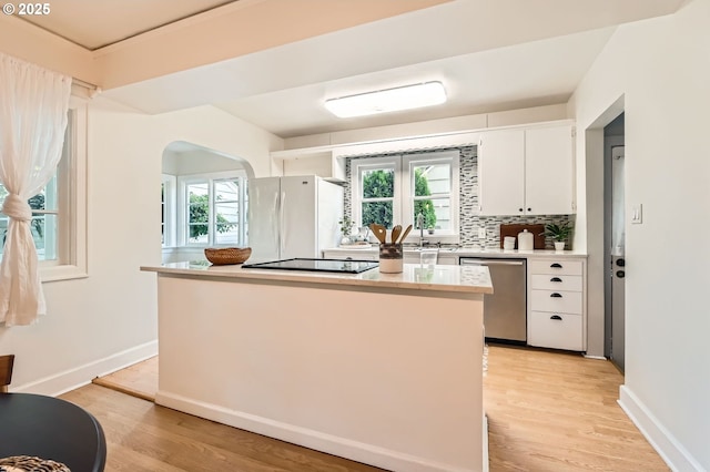 3954 NE 38th Ave, Portland, OR 97212 - kitchen featuring stainless steel dishwasher, freestanding refrigerator, black electric stovetop, light countertops, and a kitchen island