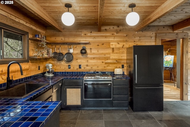 kitchen with tile counters, beamed ceiling, wooden ceiling, freestanding refrigerator, and a sink