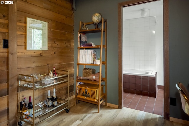 interior space with a relaxing tiled tub and wood finished floors