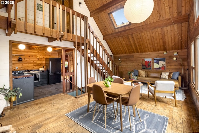 dining space with beam ceiling, wooden walls, wood ceiling, and hardwood / wood-style floors