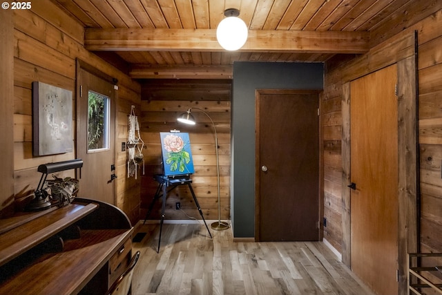 hall featuring beamed ceiling, wood ceiling, and wood walls