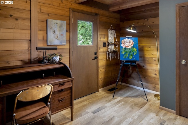 office with beam ceiling, wooden walls, light wood-style flooring, and baseboards