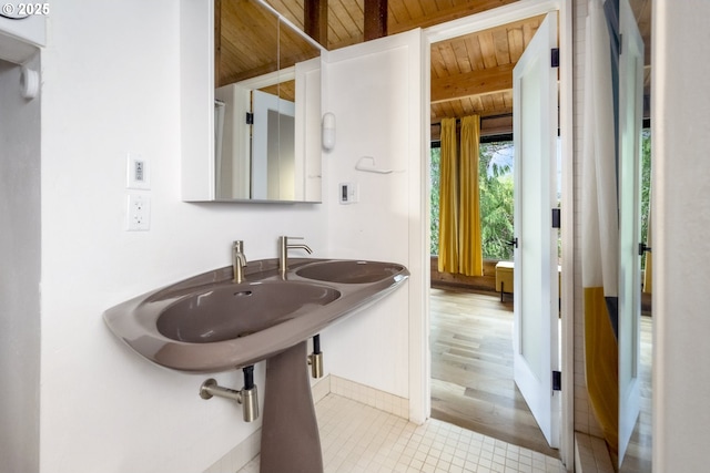 bathroom with a sink, beamed ceiling, and wood ceiling