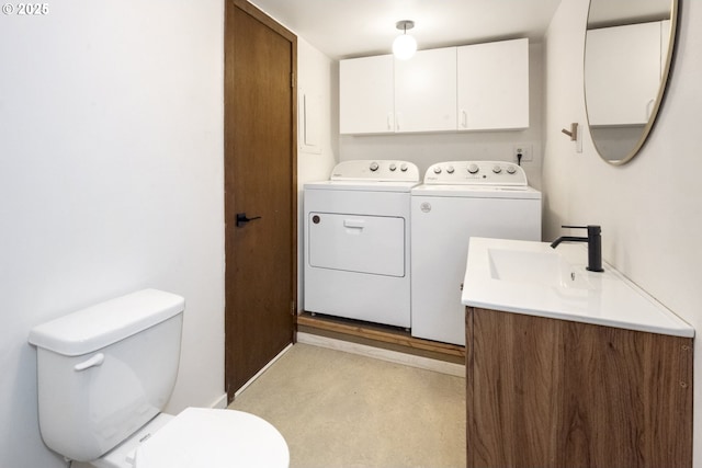 bathroom featuring toilet, vanity, and washer and clothes dryer