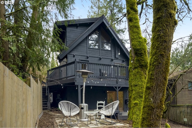 back of property featuring a patio area, a wooden deck, and a fenced backyard