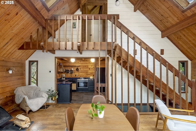 dining area with beamed ceiling, wood walls, and wooden ceiling