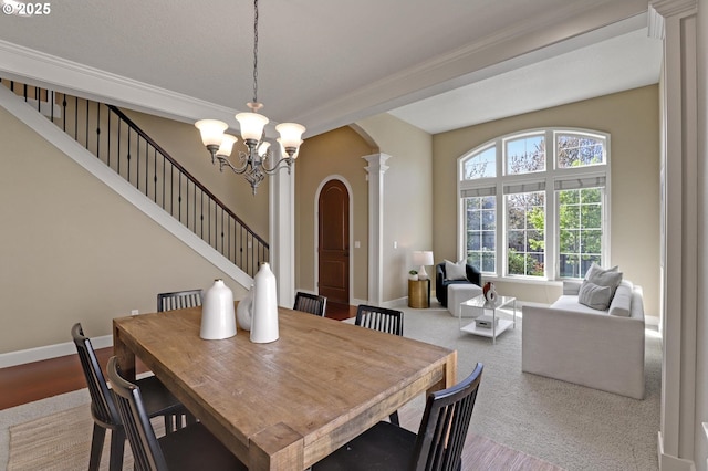 13129 NW Alvada St, Portland, OR 97229 - carpeted dining space with ornamental molding, a chandelier, stairs, ornate columns, and arched walkways