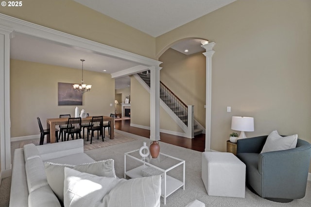 13129 NW Alvada St, Portland, OR 97229 - living area featuring decorative columns, arched walkways, stairway, a chandelier, and baseboards