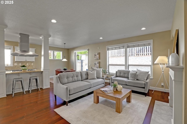13129 NW Alvada St, Portland, OR 97229 - living room with ornate columns, a textured ceiling, recessed lighting, wood finished floors, and baseboards