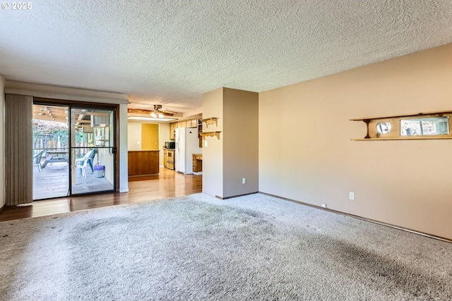 empty room with ceiling fan, a textured ceiling, and carpet floors