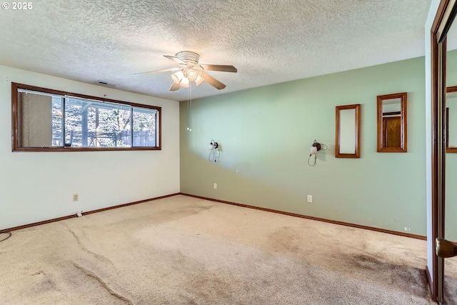 spare room featuring a textured ceiling, carpet flooring, and ceiling fan