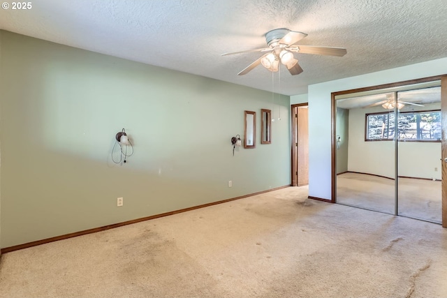 unfurnished bedroom with a textured ceiling, light colored carpet, a closet, and ceiling fan