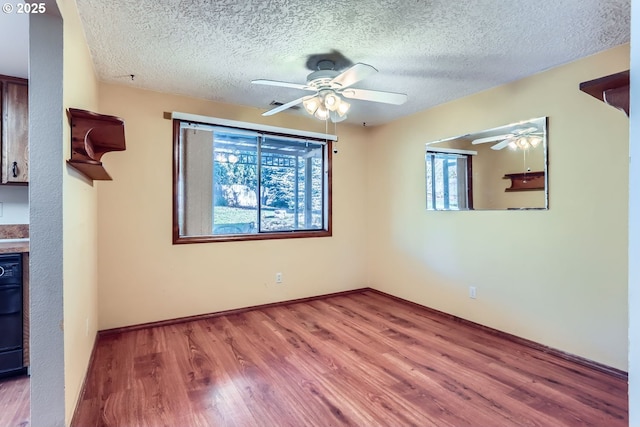 unfurnished room featuring a textured ceiling, a healthy amount of sunlight, light hardwood / wood-style flooring, and ceiling fan