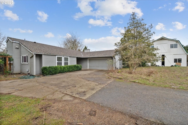 view of front of house featuring driveway, roof with shingles, and an attached garage