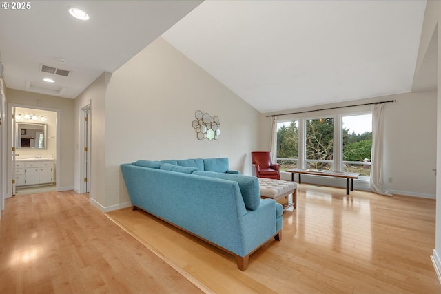 living area featuring visible vents, light wood-style flooring, and baseboards