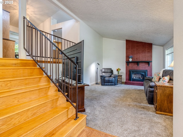 12309 SE Riveridge Dr, Vancouver, WA 98683 - carpeted living room featuring a textured ceiling, stairs, vaulted ceiling, and a brick fireplace