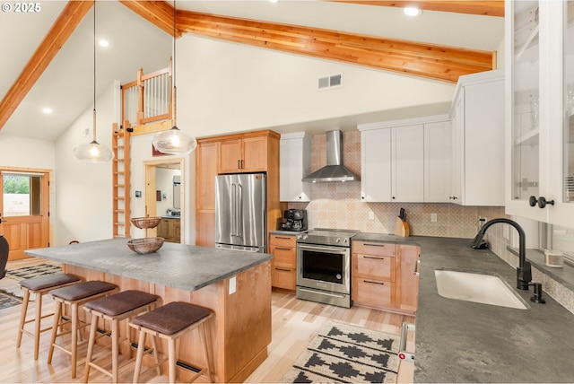 kitchen with white cabinets, beamed ceiling, wall chimney exhaust hood, decorative backsplash, and premium appliances