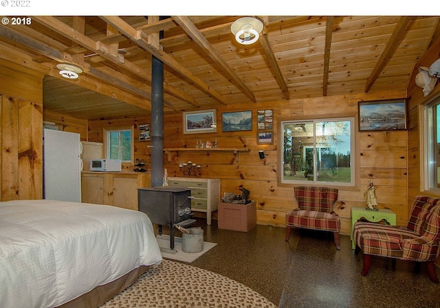 bedroom featuring wood walls, a wood stove, wood ceiling, and white fridge