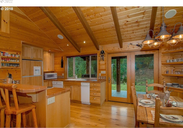 kitchen with wood ceiling, tile counters, beamed ceiling, pendant lighting, and wooden walls