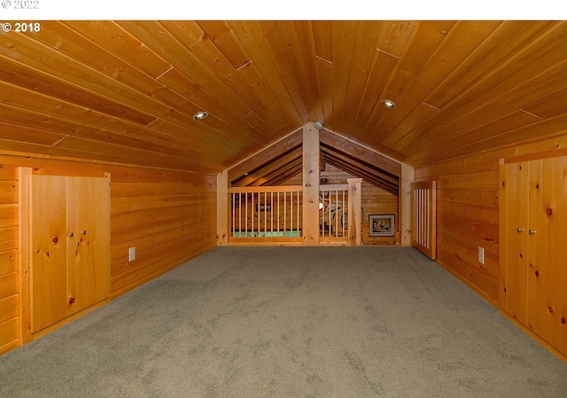 unfurnished living room featuring wood ceiling, carpet floors, lofted ceiling, and wood walls