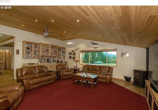 living room with wood ceiling, light wood-type flooring, ceiling fan, a wood stove, and lofted ceiling