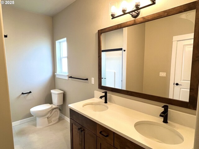 931 Medina Ave, Sutherlin, OR 97479 - bathroom with toilet, double vanity, a sink, and baseboards