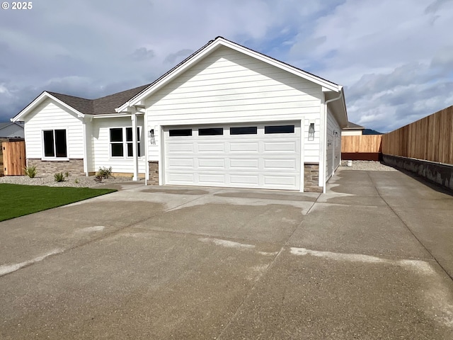 931 Medina Ave, Sutherlin, OR 97479 - single story home featuring concrete driveway, fence, stone siding, and a garage