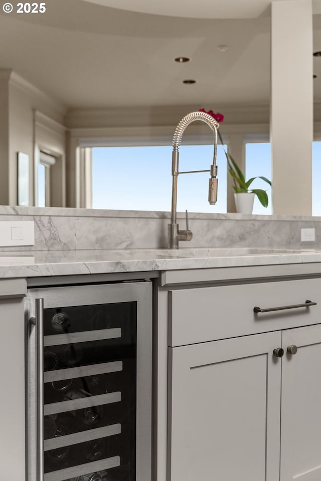 interior space with beverage cooler, light countertops, and white cabinetry