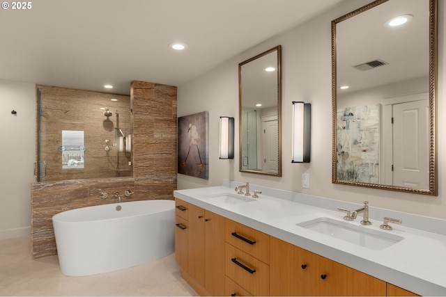 bathroom with a stall shower, a sink, and visible vents