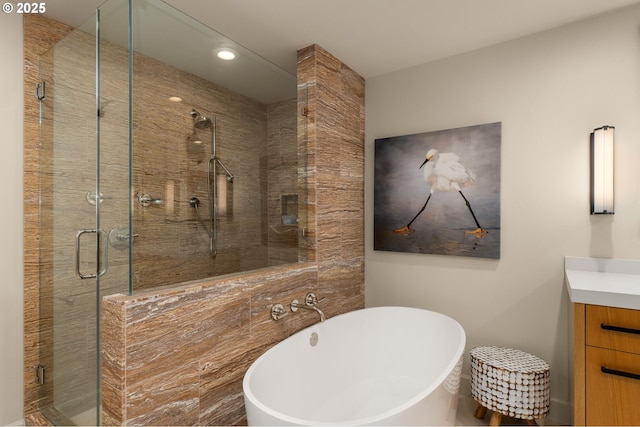 bathroom featuring a freestanding bath, a stall shower, and vanity