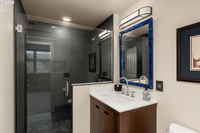 full bath featuring a stall shower, vanity, and toilet